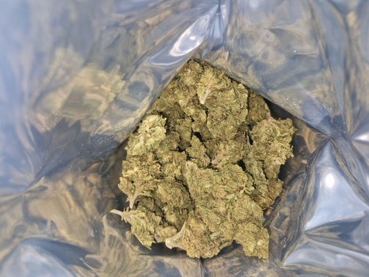 CBD-Blüten der Sorte Frosted Flakes im geöffneten Beutel mit dichten, hellgrünen Blüten.